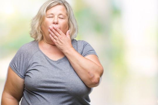 Senior plus size caucasian woman over isolated background bored yawning tired covering mouth with hand. Restless and sleepiness.