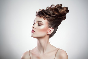 portrait of attractive brunette woman with stylish hairdo and makeup posing with closed eyes on...