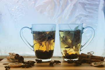 love / valentines day background with two cups of herbal tea against frozen window