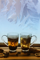 love / valentines day background with two cups of herbal tea against frozen window