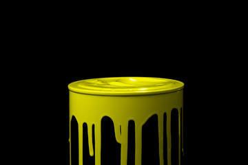 Yellow oil paint flowing down on wall of metal bucket. Isolated over black background