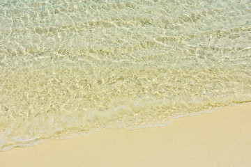 Fototapeta na wymiar Clear sea water waves on the fine sand beach of Lipe island,southern Thailand.