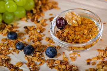 granola with milk, fresh berries and nuts in a glass plate