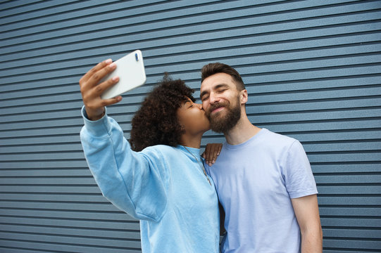 Mixed couple of hipsters in love on a street