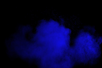 Bizarre forms of  blue powder explode cloud on black background. Launched blue dust particles splash on black background.