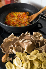 Raw ravioli and mushrooms in a kitchen during cooking