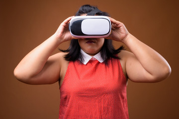 Beautiful overweight Asian woman using virtual reality VR glasses