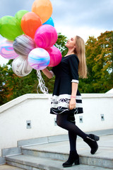Beautiful young stylish woman with multi-colored rainbow balloon