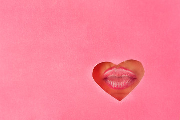 Beautiful plump, bright lips of pink color fall into the slit of colored paper. Cosmetics, cosmetics, beauty salon, makeup artist, lip gloss, sales.