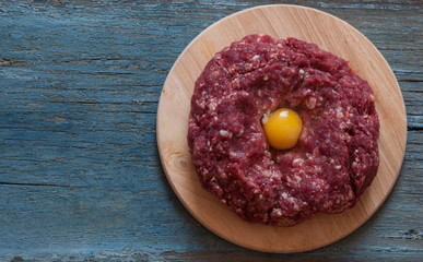Raw minced meat and other ingredients on cutting board