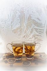 love / valentines day background with two cups of herbal tea against frozen window