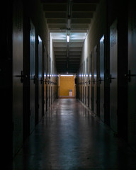 Dimly lit hallway in an abandoned storage place, dark creepy corridor