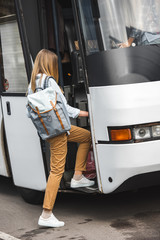 rear view of female tourist with backpack walking into travel bus at street © LIGHTFIELD STUDIOS