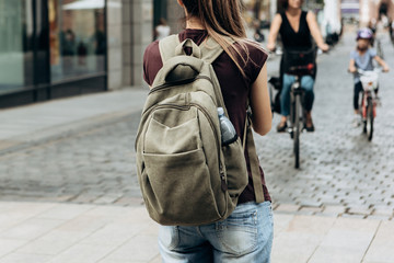 Street lifestyle. Tourist girl with backpack or student on the street in Leipzig in Germany.