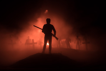 Silhouettes crowd of hungry zombies and old windmill on hill against dark foggy toned sky....