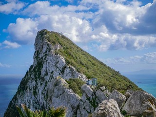 Rock of Gibraltar on a sunny day in front of the blue sky with a few clouds