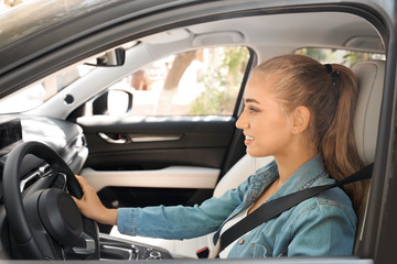Fototapeta na wymiar Female driver with fastened safety belt in car