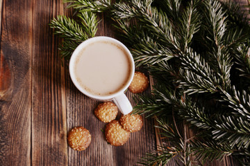 Fototapeta na wymiar Coffee with milk, hot chocolate or cocoa with cinnamon stick in a Cup and fir branches. Winter hot drink for cold weather. New year and Christmas concept