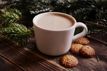 Obraz na płótnie Canvas Coffee, hot chocolate or cocoa with cinnamon stick in a cup and fir branches. Winter hot drink for cold weather. New year and Christmas concept