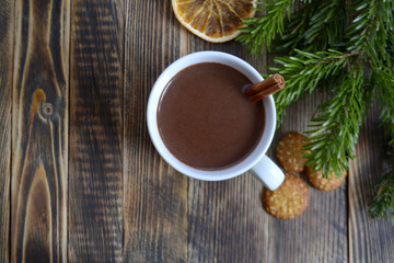 Hot chocolate or cocoa with cinnamon stick in a cup and fir branches. Winter hot drink for cold weather. New year and Christmas concept Top view Copy space