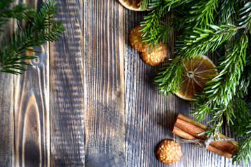 Fototapeta na wymiar Christmas and new year background frame or postcard Christmas composition with fir branches dried oranges cookies cinnamon sticks and a scarf on a wooden background