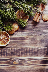 Christmas and new year background frame or postcard Christmas composition with fir branches dried oranges cookies cinnamon sticks and a scarf on a wooden background