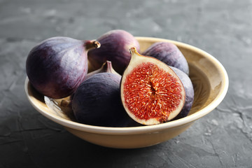 Bowl with fresh ripe figs on dark background. Tropical fruit