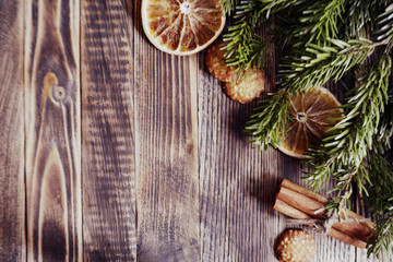 Obraz na płótnie Canvas Christmas and new year background frame or postcard Christmas composition with fir branches dried oranges cookies cinnamon sticks on a wooden background