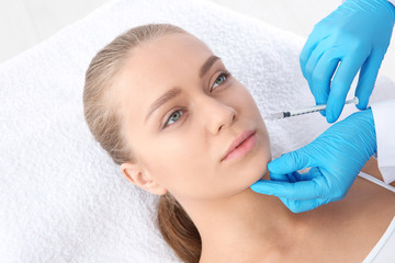 Young woman getting facial injection in clinic. Cosmetic surgery concept