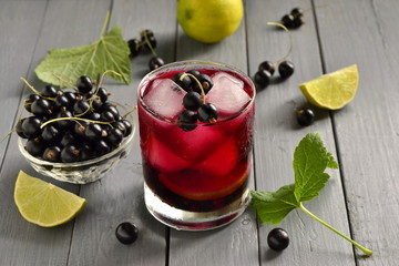 Cold lemonade with black currant, lime and ice cubes