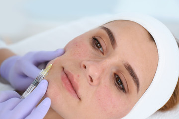 Woman undergoing face biorevitalization procedure in salon, closeup. Cosmetic treatment