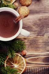 Hot chocolate or cocoa with cinnamon stick in a cup and fir branches. Winter hot drink for cold weather. New year and Christmas concept Top view