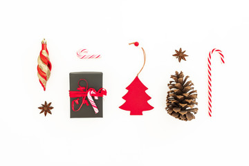 Fototapeta na wymiar Christmas gift, pine cone, toys and candy cane on white background. Flat lay, top view. Creativity New Year concept