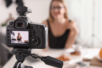 Food blogger recording video indoors, focus on camera display. Space for text