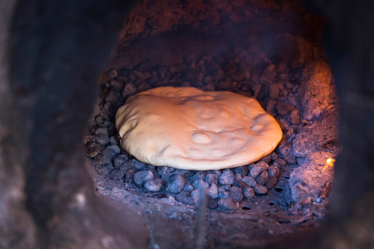 Moroccan traditional bread cooked over a wood fire in the village of Dar Isdelay, Morocco