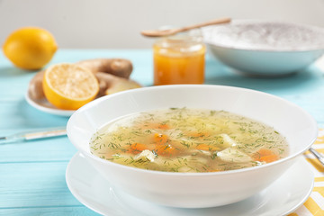 Bowl of fresh homemade soup to cure flu on wooden table