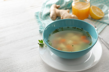 Bowl of fresh homemade soup to cure flu on wooden table