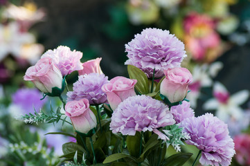 Fototapeta premium closeup of artificial flowers on tomb in cemetery
