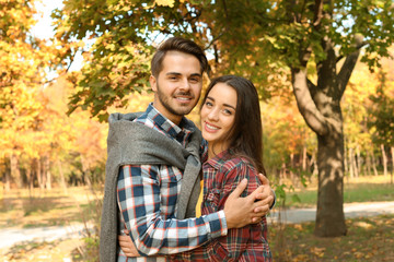 Young lovely couple spending time together in park. Autumn walk