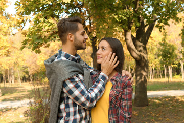 Young lovely couple spending time together in park. Autumn walk