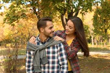 Young lovely couple spending time together in park. Autumn walk