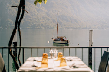 Mesa con platos con vistas de un lago con un barco