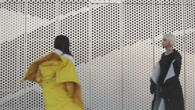 Two women walking by each other