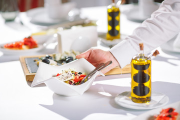 Waiter serving table in the restaurant preparing to receive guests.