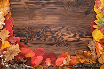 autumn leaves, acorns and flowers on wooden background