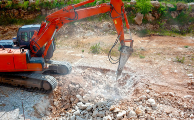 Close up of a heavy duty construction industry excavator machine crushing stones in a construction...