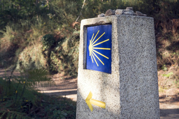 Camino de Santiago milestone with blurred path. Way of St. James