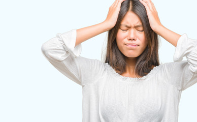 Young asian woman over isolated background suffering from headache desperate and stressed because pain and migraine. Hands on head.