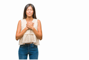 Young asian woman over isolated background smiling with hands on chest with closed eyes and grateful gesture on face. Health concept.