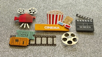 tub of popcorn with cinema sign and 3d glasses movie tickets on film strip projector film reel and...